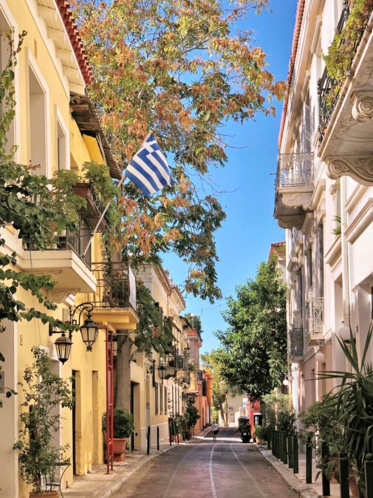 узкая улица между домами и флаг Греции